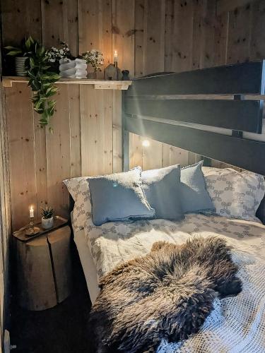 a bedroom with a bed with a wooden wall at Modern Hand-Crafted Log Cabin in Dovreskogen