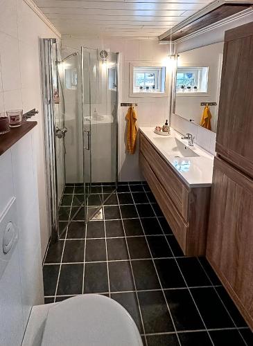 a bathroom with a shower and a sink and a toilet at Modern Hand-Crafted Log Cabin in Dovreskogen