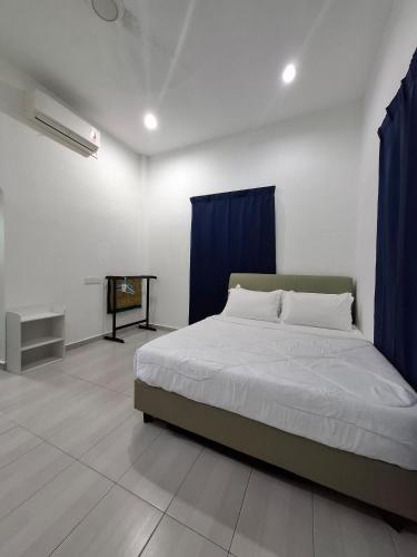 Guesthouse Sungai Musoh في بينجرانج: غرفة نوم مع سرير مع ستائر زرقاء وتلفزيون