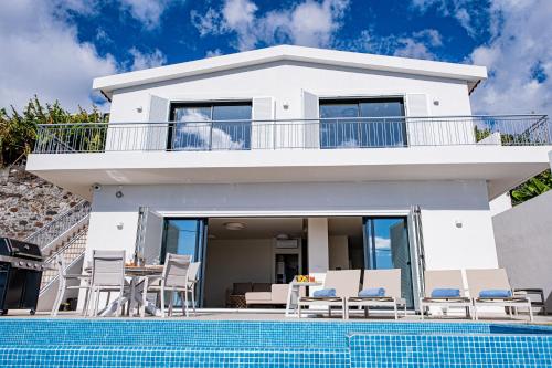 a villa with a swimming pool and a house at Villa Infinityviews Madeira in Câmara de Lobos