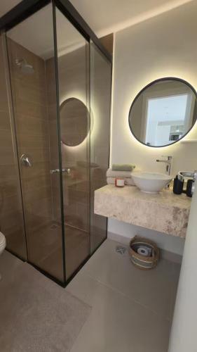 um banheiro com chuveiro, pia e espelho em Edificio Zuba 11 Hermoso Apartamento de 2 Habitaciones en Encarnacion! em Caña de Castilla