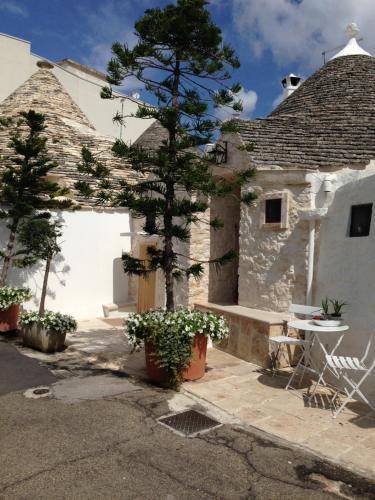 una casa con un albero di fronte di Resort Romano in Trulli ad Alberobello