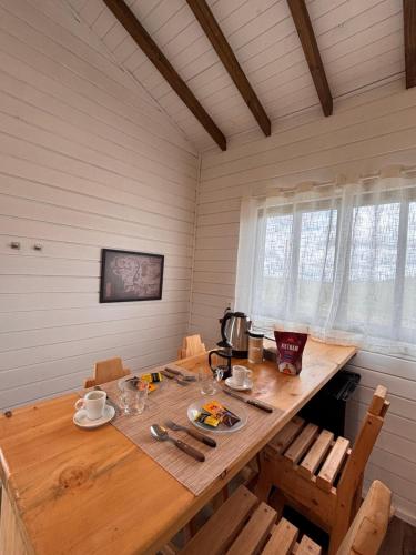 een houten tafel in een eetkamer met een waterkoker bij Cabana Jardim das Nuvens in Urupema