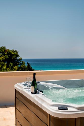 a bottle of wine sitting in a bath tub with the ocean at Costiero Elegant Suite Gallipoli Mare in Gallipoli