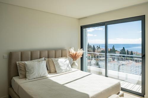 una camera da letto con un letto con vista sull'oceano di Villa Infinityviews Madeira a Câmara de Lobos