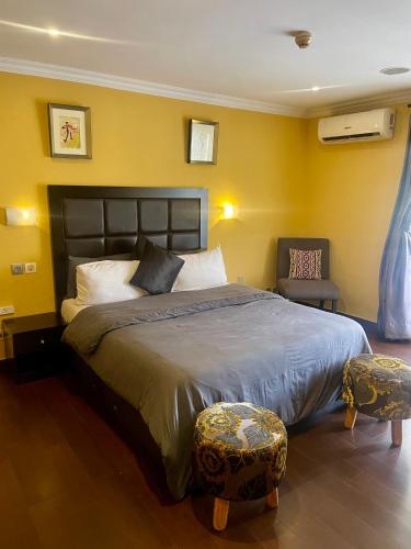 a bedroom with a large bed and a chair at Angel Hotels in Lagos