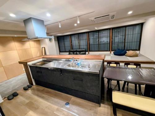 eine Küche mit einer großen Kochinsel und einem Tisch mit Stühlen in der Unterkunft Rou in Nozawa Onsen