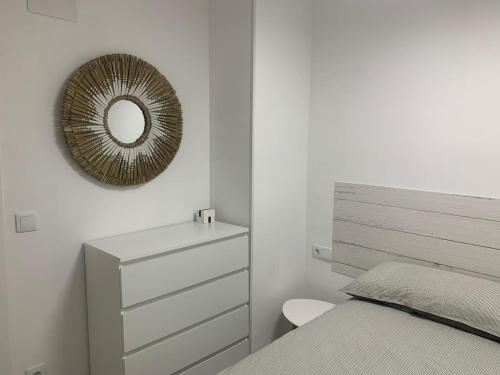 a bedroom with a bed and a mirror and a dresser at Penismar Paradis in Peniscola
