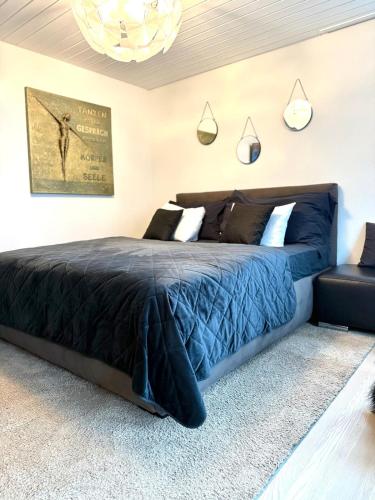 une chambre avec un lit recouvert d'une couette bleue dans l'établissement Luxus Studio Apartment am Bodensee, à Güttingen