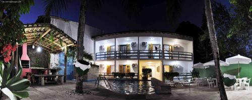 a building with a pool in front of it at night at Hotel Estalagem Porto Seguro in Porto Seguro