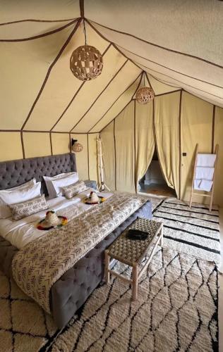 ein Schlafzimmer mit einem Bett mit zwei Enten darauf in der Unterkunft Starlit Luxury Camp in Merzouga