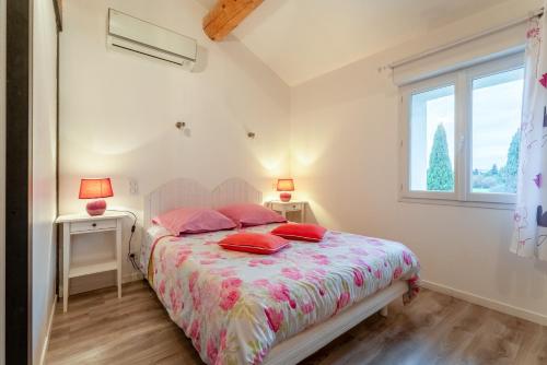 Chambre Laurier Rose في Piolenc: غرفة نوم بسرير وطاولتين ونافذة