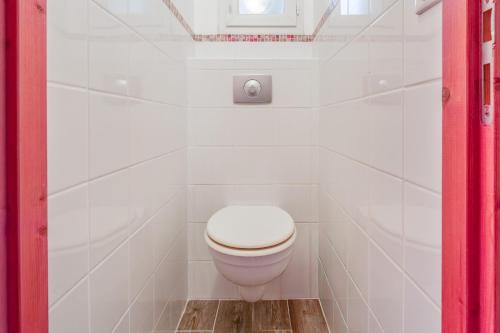 Chambre Laurier Rose في Piolenc: مرحاض أبيض في حمام من البلاط الأبيض