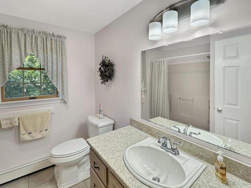 a bathroom with a sink and a toilet and a mirror at Family Retreat at York Beach in York