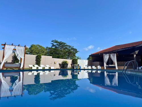 una piscina in un resort con sedie e un padiglione di Manacá Hotel a Foz do Iguaçu