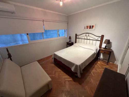 ED. EL ARANZAL في بونتا دل إستي: غرفة نوم بسرير واريكة ونوافذ