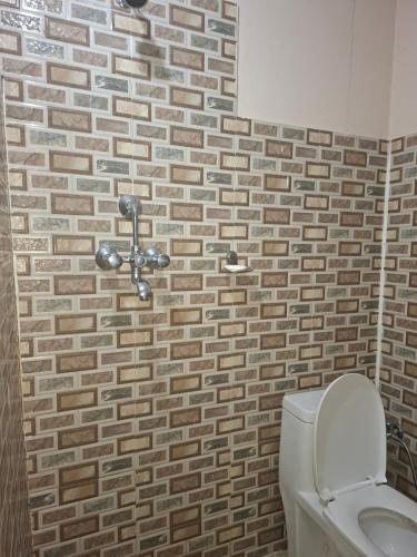 baño con aseo y pared de ladrillo en Lake mirror, en Pokhara