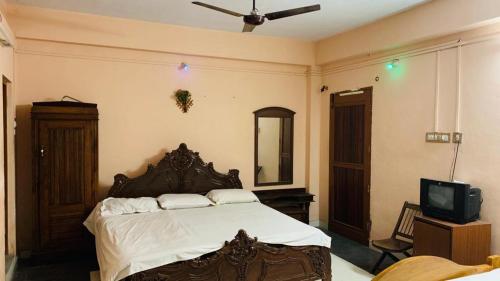 a bedroom with a large bed and a tv at JS Homestay in Nāgercoil