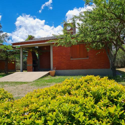 a red brick building with a clock tower on top at Complejo Ayllu in Las Rabonas