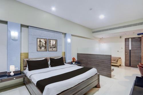 a bedroom with a large bed and a couch at Townhouse Kakinada Nagamalli Thota Junction in Kākināda