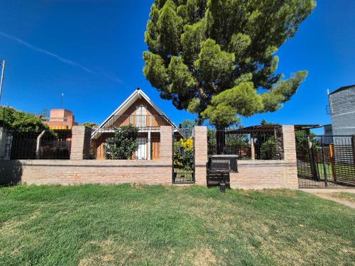 a house with a fence and a tree at La Casa De Yayo in San Luis