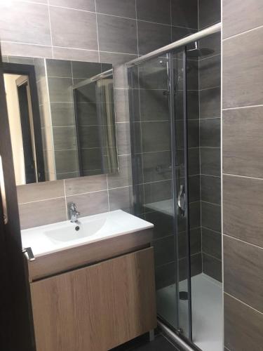 a bathroom with a sink and a glass shower at Les vacances in Sainte-Maxime