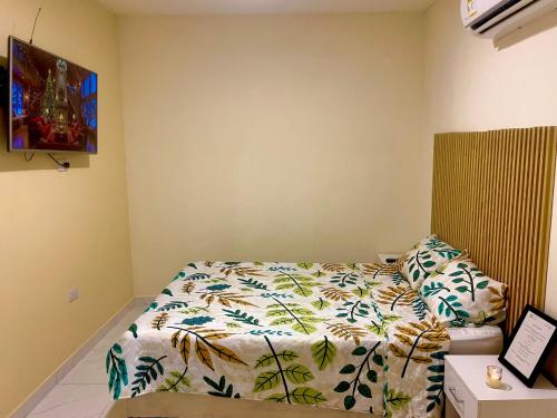 a bedroom with a bed with a comforter on it at Casa Agarj in Santa Marta