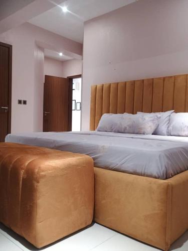 a bedroom with a large bed with a wooden headboard at EXCLUSIVE ANSO Homes GRA Ikeja 1 bed room in Ikeja
