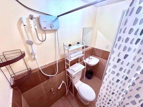 Un baño con ducha, inodoro y lavabo. en PAID AirprtPck-up WrkNrelax 2TV with Netflx, en Lanang