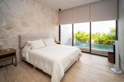 een slaapkamer met een wit bed en een groot raam bij Luxury Designer Villa Pool & Gym in Cancun