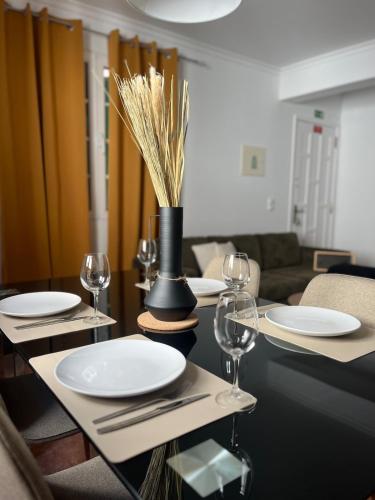 ein Esstisch mit Tellern und Weingläsern in der Unterkunft Brisa do Norte apartment in São Vicente