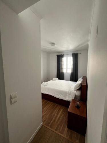 ein Schlafzimmer mit einem Bett und einem Tisch darin in der Unterkunft Brisa do Norte apartment in São Vicente