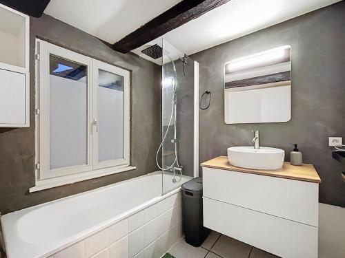 バールにあるCocon au cœur des vignes et de la vieille villeのバスルーム(シンク、バスタブ、鏡付)