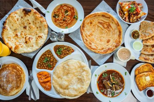 uma mesa com pratos de comida sobre uma mesa em Hotel Grand Orchard Two em Lahore