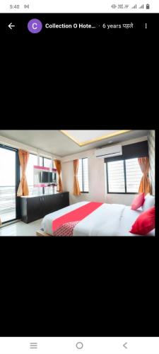 a picture of a bedroom with a bed with red pillows at Hotel paladise in Ahmedabad