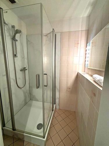 a shower with a glass door in a bathroom at Markt Eins Salonwohnung in Schöppenstedt