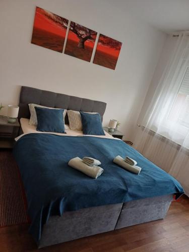 a bedroom with a blue bed with two towels on it at Apartman Gaby in Virovitica
