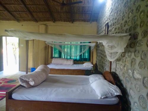 1 dormitorio con 2 camas y dosel en Mango Tree Lodge, en Bhurkīā