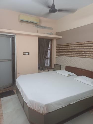 a large white bed in a room with a window at JS Homestay in Nāgercoil