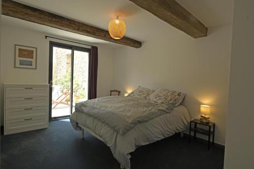 ein Schlafzimmer mit einem Bett in einem Zimmer mit Fenster in der Unterkunft La maison du merle bleu in Quintillan
