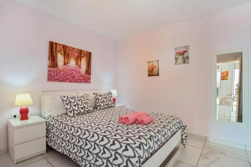 a bedroom with a bed with two pink pillows on it at Rosa eden in La Asomada
