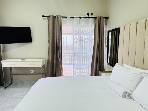 En eller flere senge i et værelse på Palms Guest House