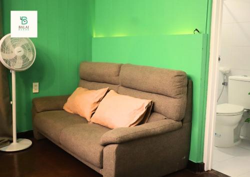 a couch with a pillow and a fan in a room at Balai Berde Baguio in Baguio