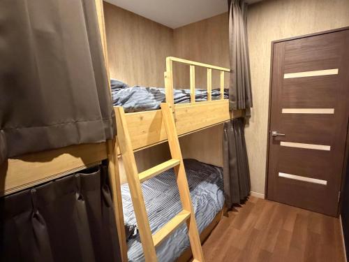 um quarto beliche com 2 beliches e uma porta em A Lucky Hostel em Hakuba
