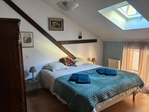 a bedroom with a bed with two blue towels on it at Le petit nid de Turckheim avec parking privé in Turckheim