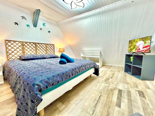 une chambre avec un lit recouvert d'une couette bleue dans l'établissement L'Envolée, centre ville parking gratuit, à Villeneuve-sur-Yonne