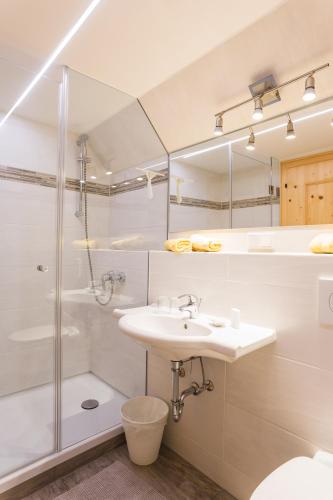 a white bathroom with a sink and a shower at Ferienhaus zur Hackenschmiede in Mauterndorf