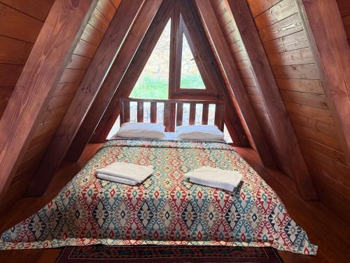 a bed in a wooden room with a window at Sayat Nova Home in Dilijan
