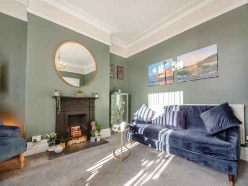 a living room with a blue couch and a mirror at Jack's House- Uk40741 in Tywyn