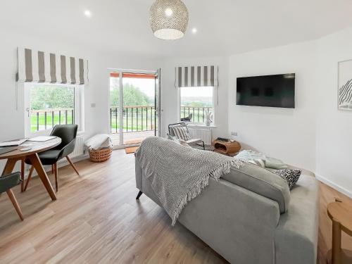 ein Wohnzimmer mit Sofa und Tisch in der Unterkunft The Rabbit Hole - Uk50123 in Bodelwyddan